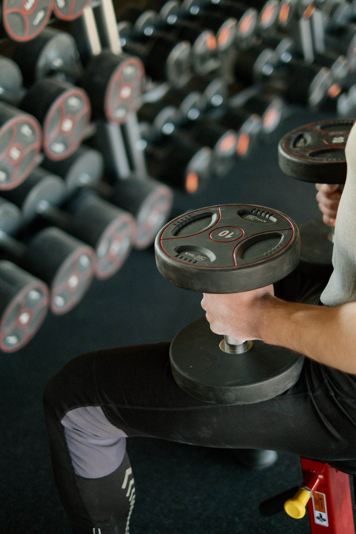 Athletes training with barbells in a dark gym